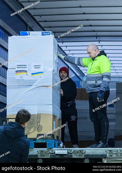 20 December 2023, North Rhine-Westphalia, Cologne: Electricity generators are loaded into a truck at the ""Blue-Yellow Cross"" donation warehouse