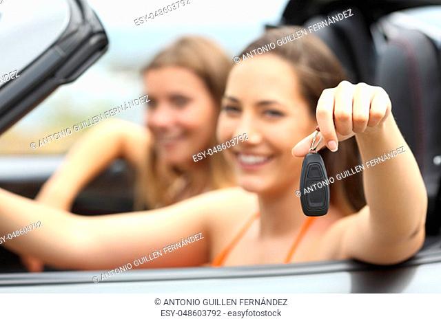 Two happy tourists showing a rental car keys on summer vacations