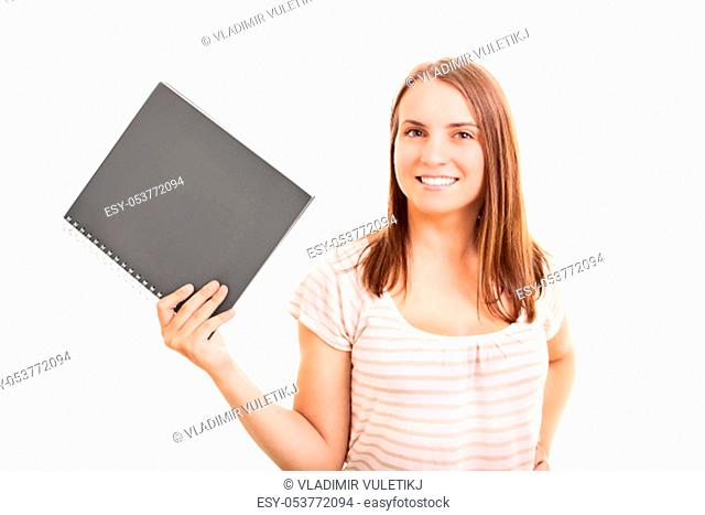 Smiling young student girl holding a notebook, isolated on white background