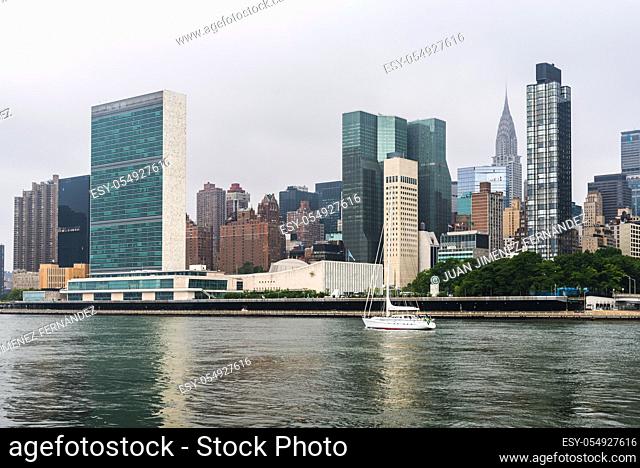 Sailing ship on East River against skyline of Midtown of New York City a misty day