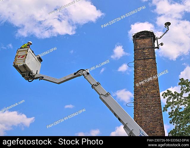 PRODUCTION - 04 July 2023, Brandenburg, Falkenberg: Stefan Blüher, an electrician with the electricity company Mitnetz, drives in a lifting platform to the...
