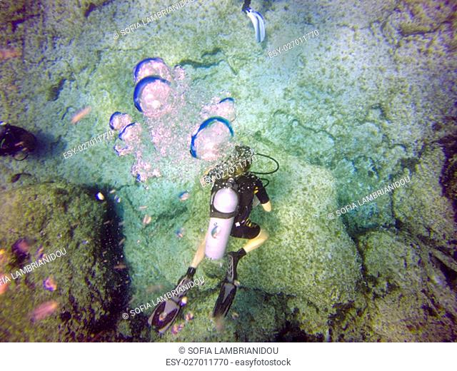 A scuba diver's bubbles from the top. View of the scuba diver gear, fins, tank, swimming underwater in the deep blue clear sea of Protaras, Cyprus