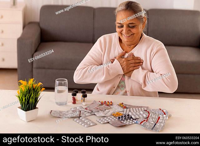 Old woman going to take medicine kept on centre table
