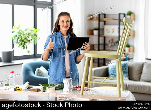 woman with tablet pc and old chair shows thumbs up