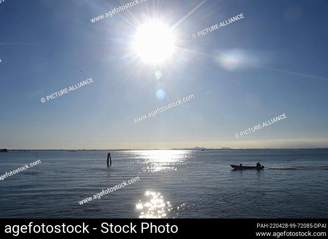 27 April 2022, Italy, Pellestrina: A boat sails across the sea in the sunshine at Pellestrina. Pellestrina is an island and forms part of the closure of the...