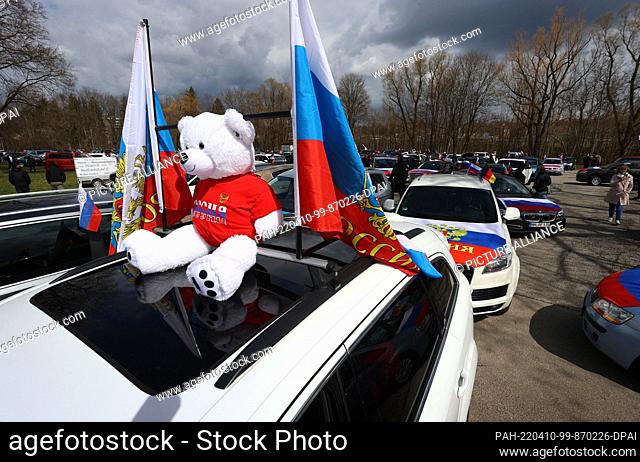 10 April 2022, Bavaria, Kaufbeuren: A teddy bear and Russian flags are mounted on a car at the Tänzelfestplatz. The square is the starting point of a...