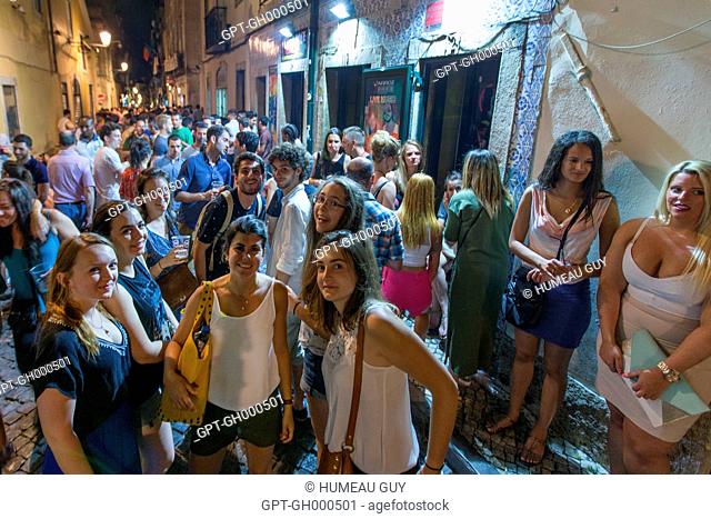 YOUTH IN THE STREETS OF ALFAMA, FESTIVE NIGHTTIME AMBIANCE, LISBON, PORTUGAL