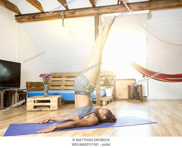 Young woman practicing yoga in attic
