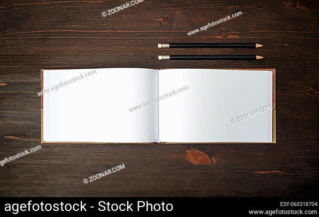 Blank sketchbook and pencils mock up on wooden background. Template for placing your design. Flat lay