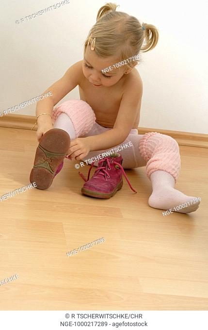 Little Child with Pantyhose Dresses her Shoes