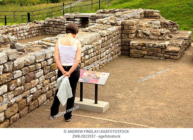Woman reading information sign. Chesters Roman Fort and Museum bathhouse. Chollerford, Hexham, Northumberland, England, United Kingdom, Europe