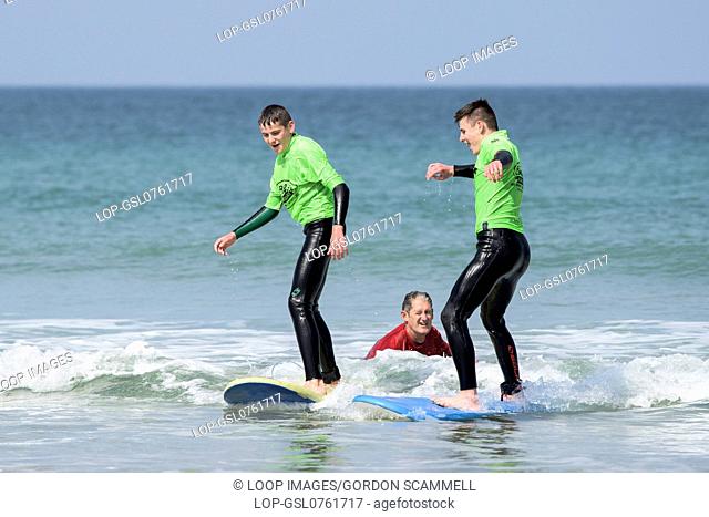 A surf school instructor teaching novices on Fistral Beach in Newquay in Cornwall