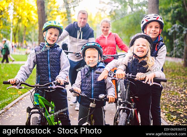 Theme family sports vacation in park in nature. big friendly Caucasian family of six people mountain bike riding in forest