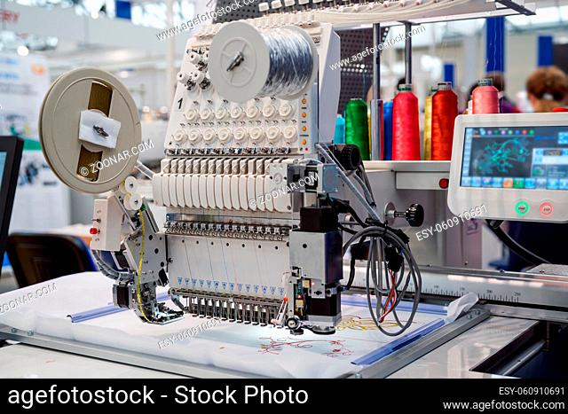 Automatic industrial sewing machine for stitch by digital pattern. Modern textile industry