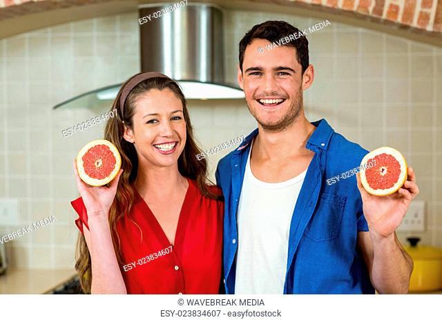 Couple holding slices of blood orange
