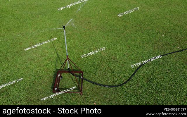 High angle view auto watering system to green grass in hot sunny day
