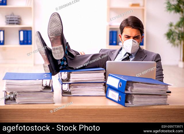 Young businessman employee working at workplace during pandemic