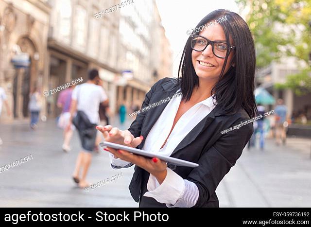 Smiling Businesswoman Using Tablet Computer on street, Business woman