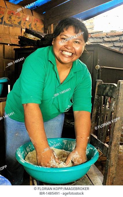Friendly smiling woman kneading dough with her hands in her backyard bakery, San Ignacio, Chiquitania, Santa Cruz Department, Bolivia, South America