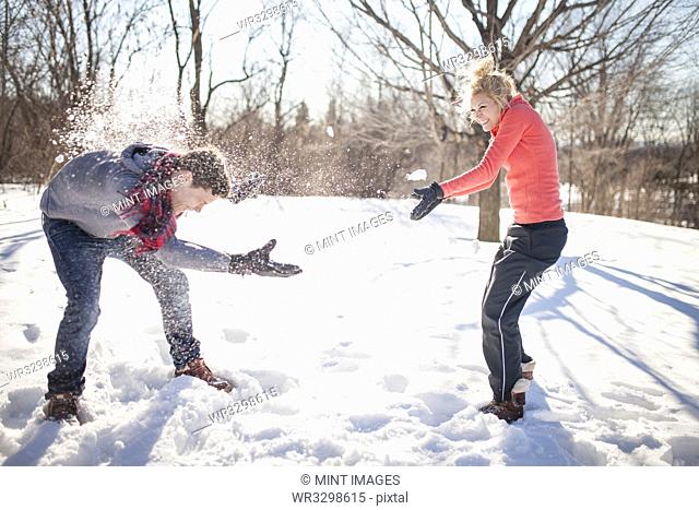 Caucasian couple having snowball fight