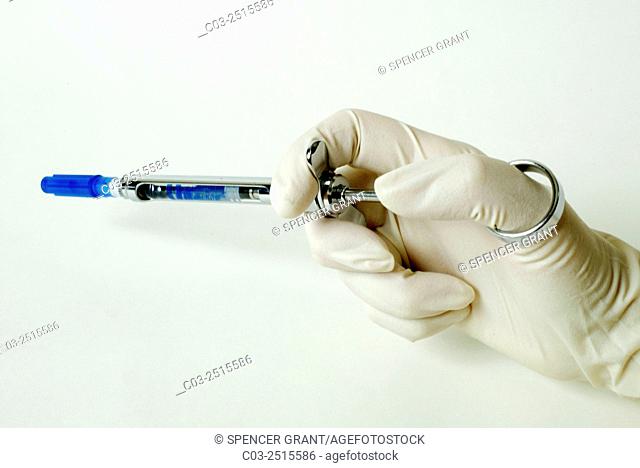 A novocaine carpule is inserted into a anesthetic syringe by a dentist. A carpule is a type of ampule or cartridge containing liquid medication