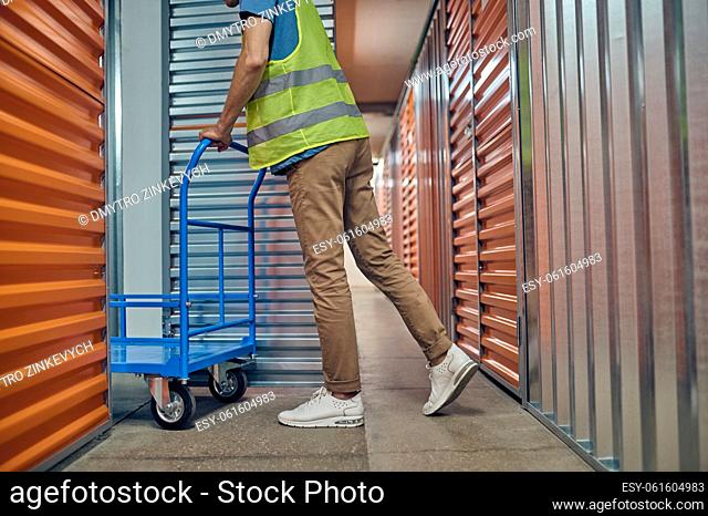 Cropped photo of an employee wheeling the platform cart through an open door of the cargo container