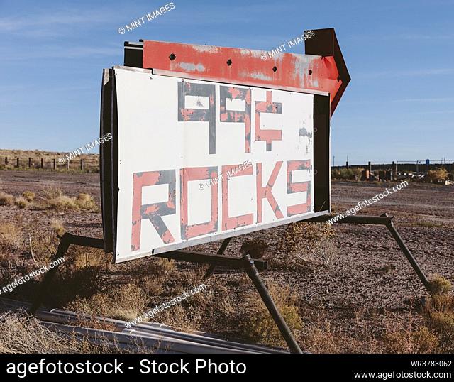 Rusty roadside sign advertising a reststop, deserted trucks and rubbish