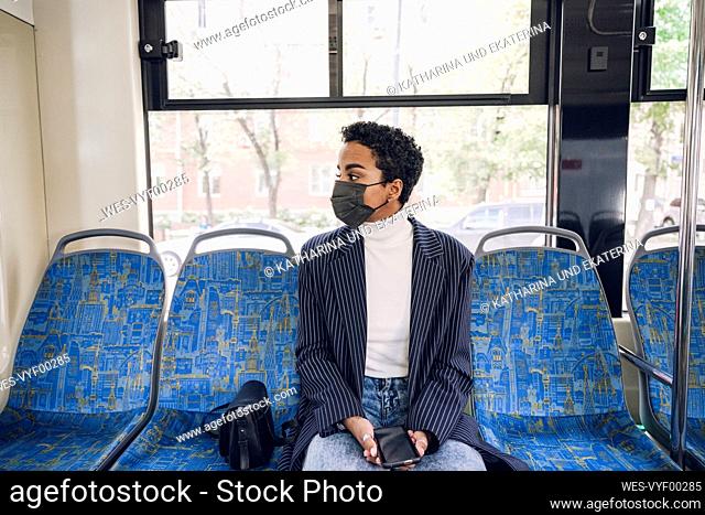Young businesswoman traveling in bus during COVID-19