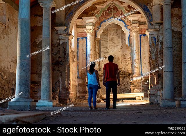 Caucasian couple in Juromenha abdandoned castle church interior in ruins in Alentejo, Portugal