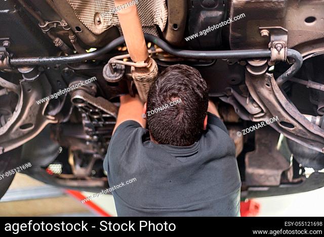Mechanic repairing exhaust system