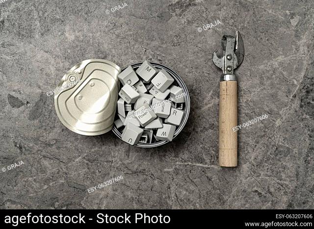 Knowledge seeking concept: can opener and tin can full of computer keyboard keys on the stone background