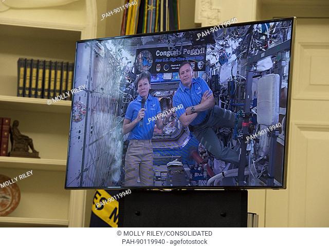 NASA Astronauts Peggy Whitson and Jack Fischer appear on a video screen as United States President Donald Trump hosts a video conference with then aboard the...