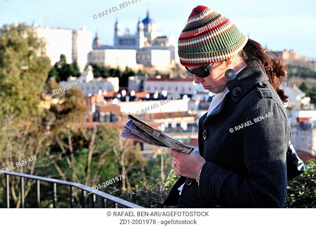 Spanish lady reading a map of Madrid at a lookout of the Royal Palace and Almudena Cathedral Madrid, Spain