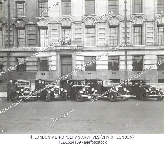 Official London County Council cars and chauffeurs, County Hall, London, 1935. Austin cars parked with drivers in caps and coats standing beside outside the...