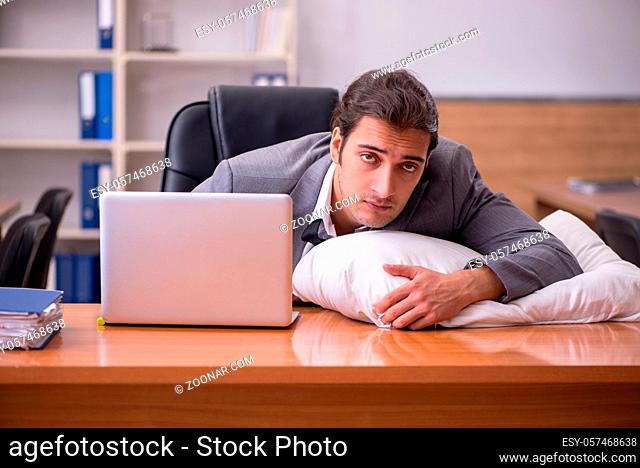 Young employee sleeping at workplace