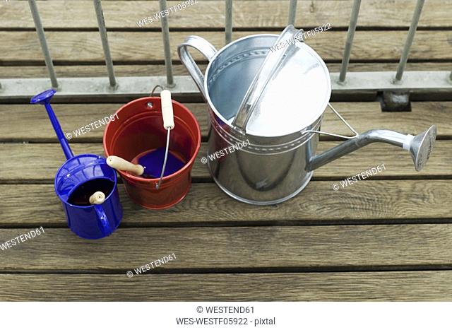 Watering cans and bucket on balcony