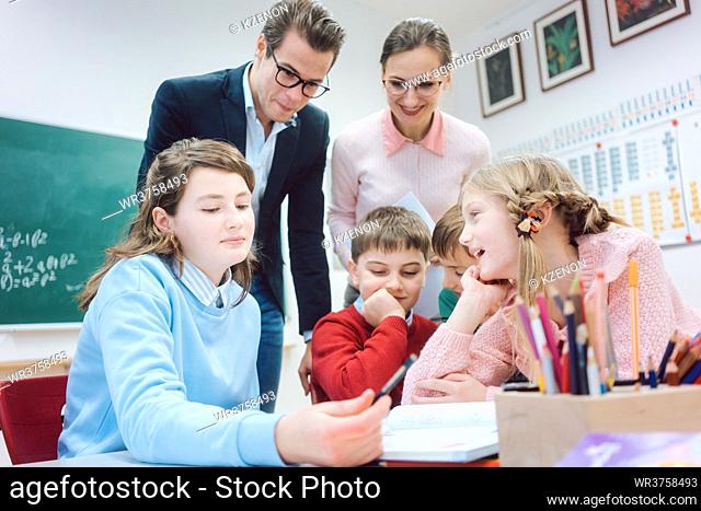 Group work session in school with teachers and pupils together on a desk