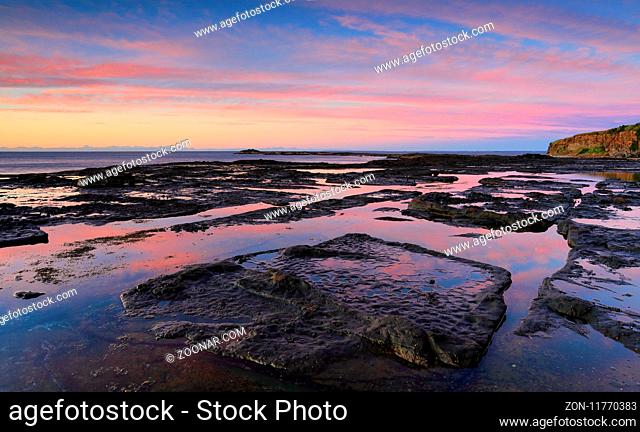 Tidal reflections along the exposed rockshelf on the coast at Geroa Australia