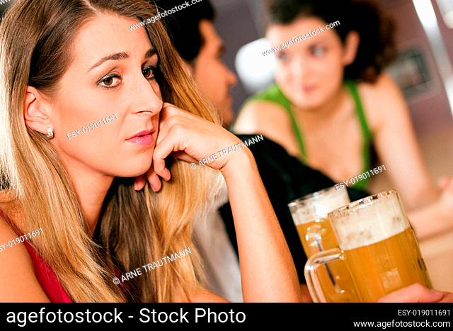 Leute in einer Bar, Frau ist traurig