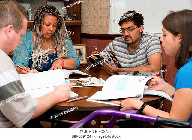 Multiracial group of students in study group, one has cerebral palsy and uses a walking frame