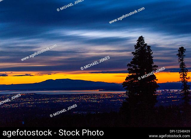 The setting sun over Alaska's Mount Susitna, locally known as 'The Sleeping Lady', with the Cook Inlet and the city of Anchorage in the foreground as seen from...