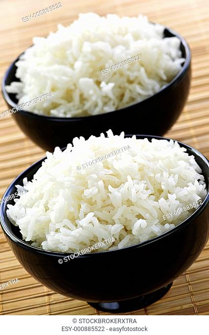 White steamed rice in two black round bowls