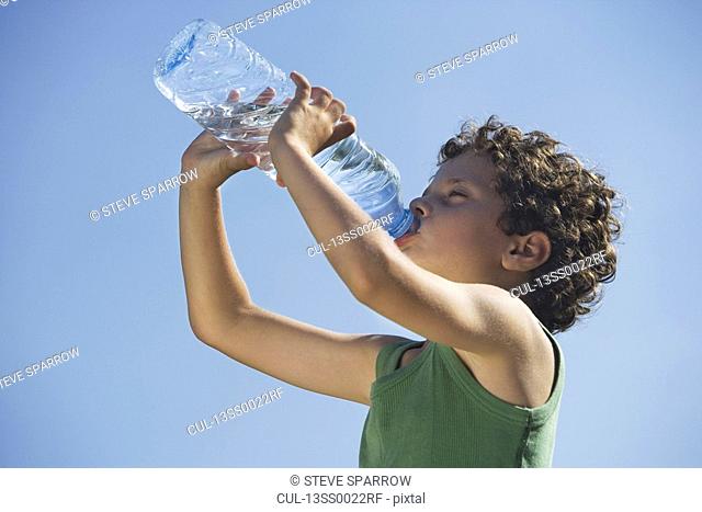 Low angle of young boy drinking water