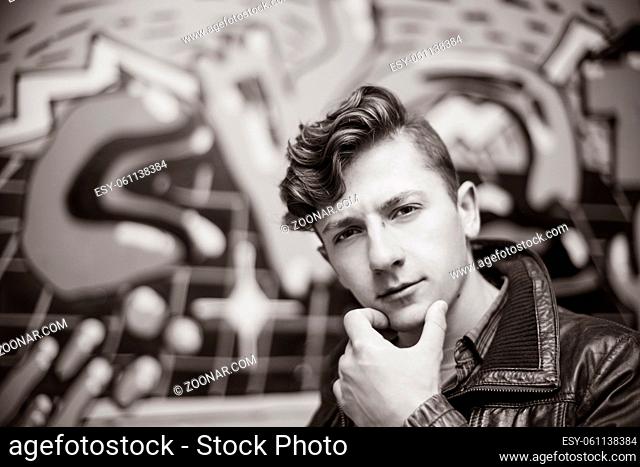 portrait of a guy in a leather jacket among the shabby walls
