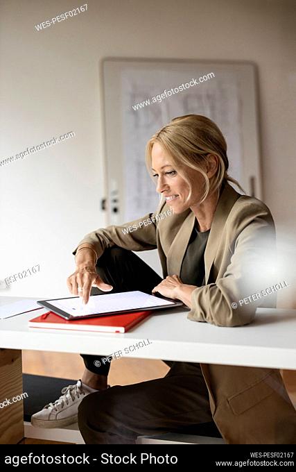 Businesswoman working on digital tablet while sitting at home