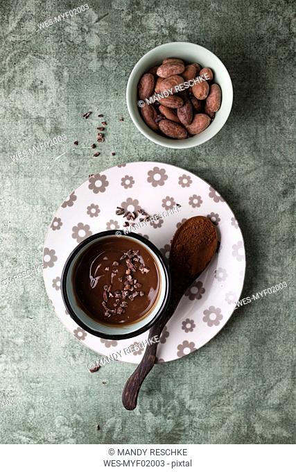 Cup of chocolate pudding with cacao, cacao nibs and cocoa beans