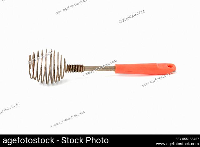 very old kitchen utensil for beating eggs, liquids with a handle isolated on a white background
