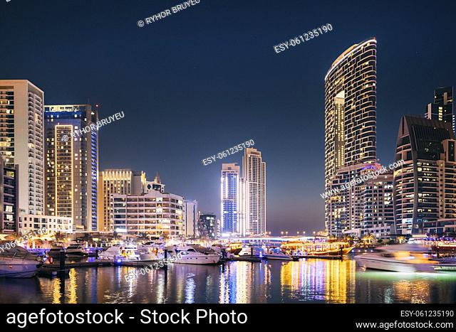 Dubai Marina Port, UAE, United Arab Emirates - Beautiful Night View Of Dubai Marina Skyline. Yachts Moored Near City Pier, Jetty In Evening Night Illuminations
