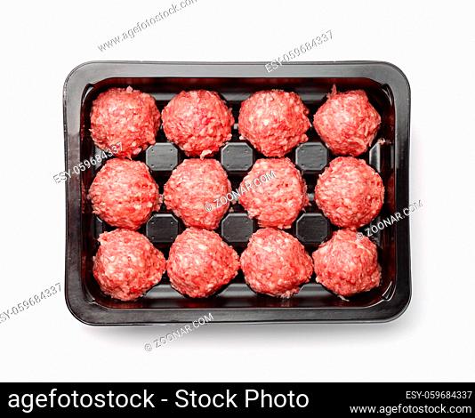 Top view of raw beef meatballs in plastic tray isolated on white