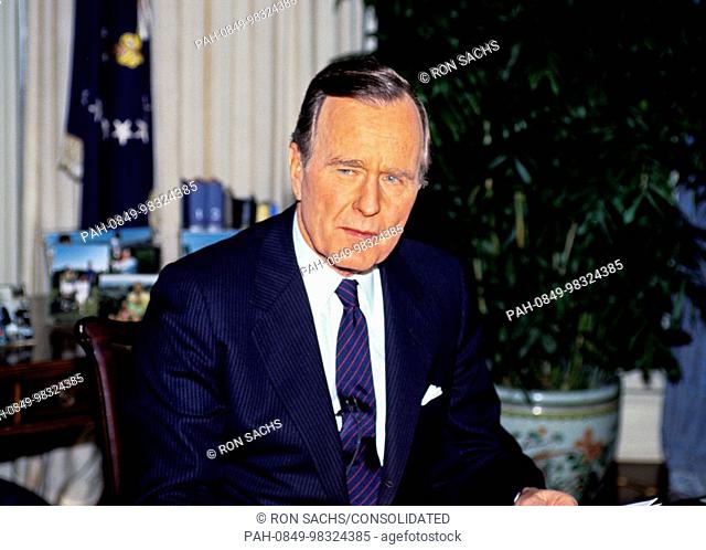 United States President George H.W. Bush poses for photos in the Oval Office of the White House in Washington, D.C. after announcing the start of the air...